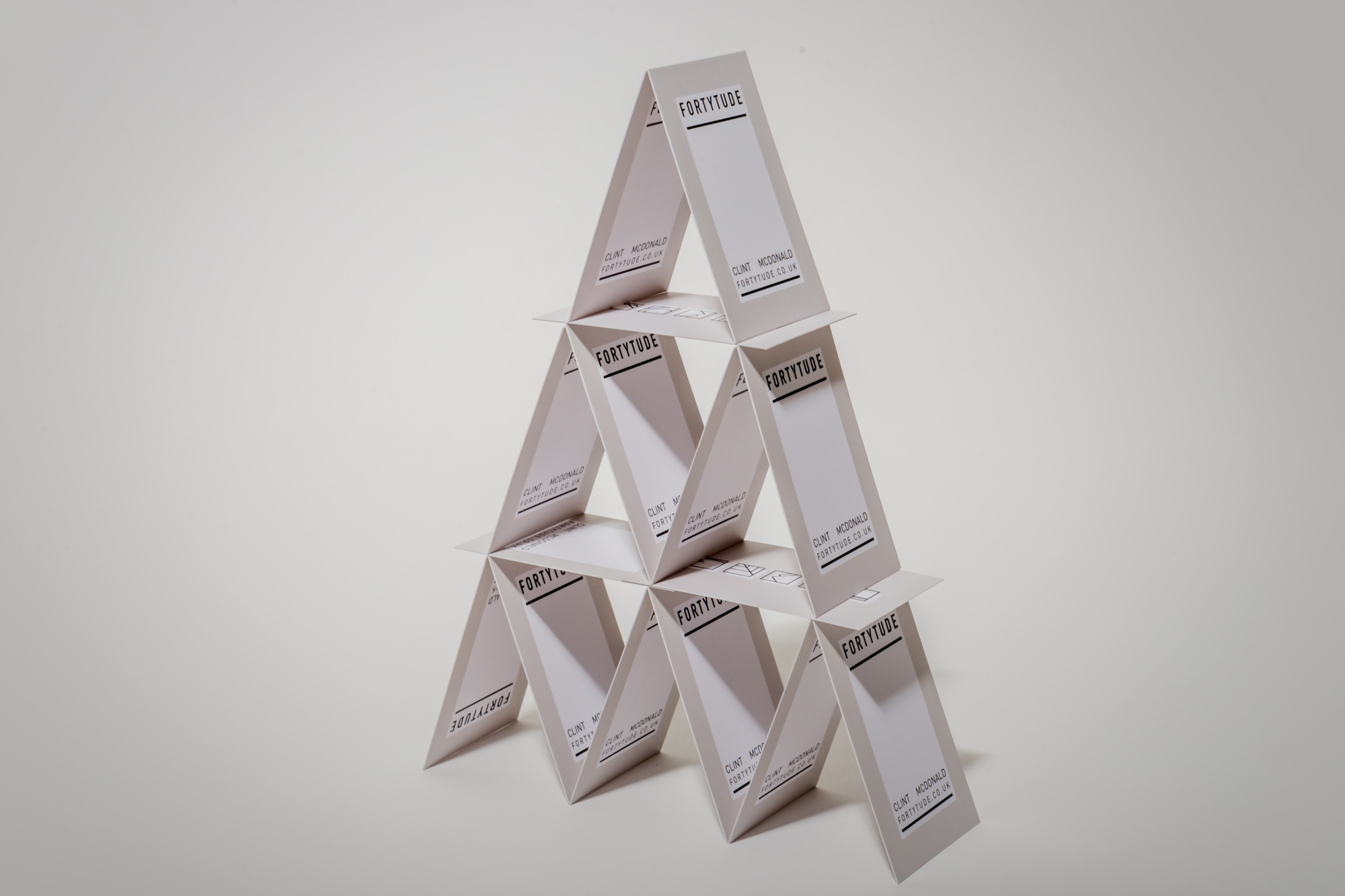 A tower made out of business cards for Fortytude- slight silhouette behind. Graphic design produced by Barefaced Studios, design agency based in Islington, North London.